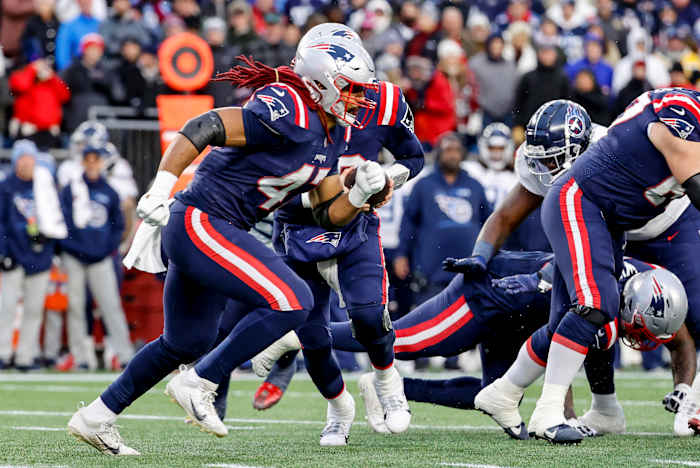 Jakob Johnson runs toward the line of scrimmage to deliver a block during a game against the Titans